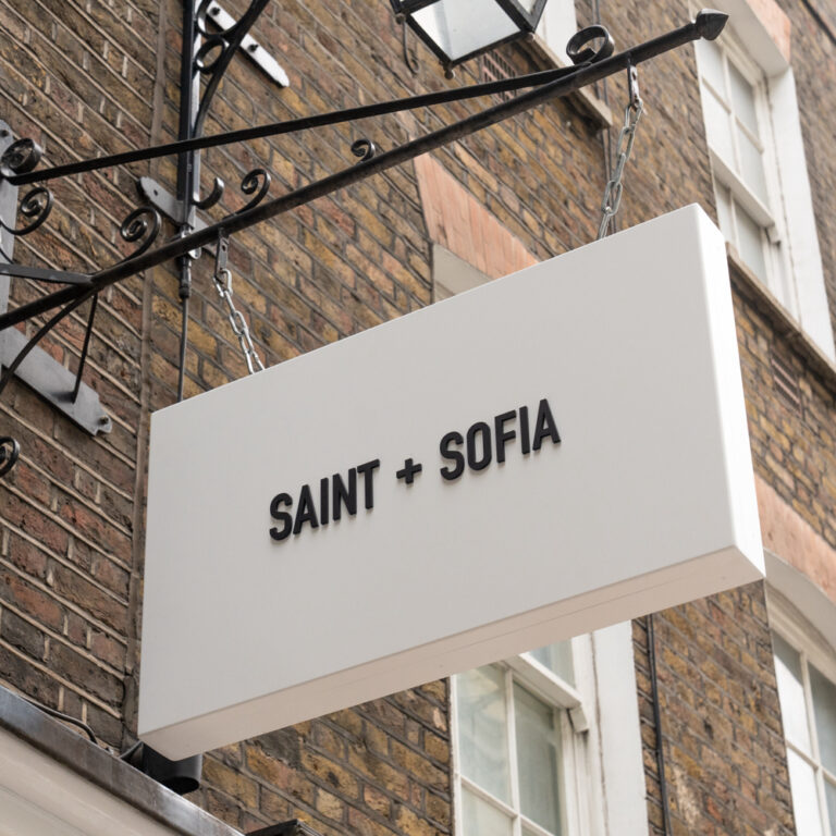 White sign with Saint + Sofia on the front in black
