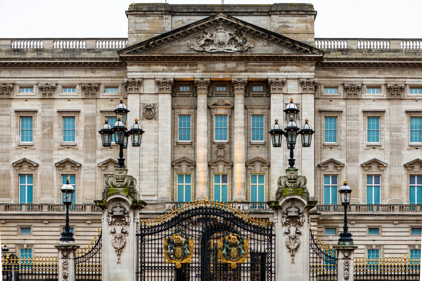 A picture of Buckingham Palace from the front, beyond the gates.