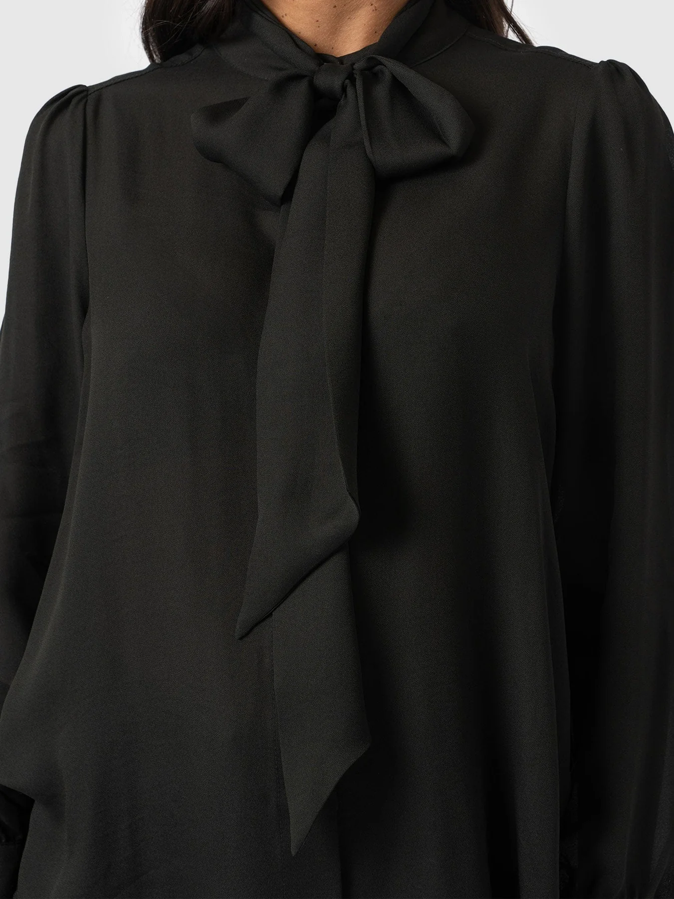 A black blouse with a pussybow neckline from the Saint and Sofia November collection.