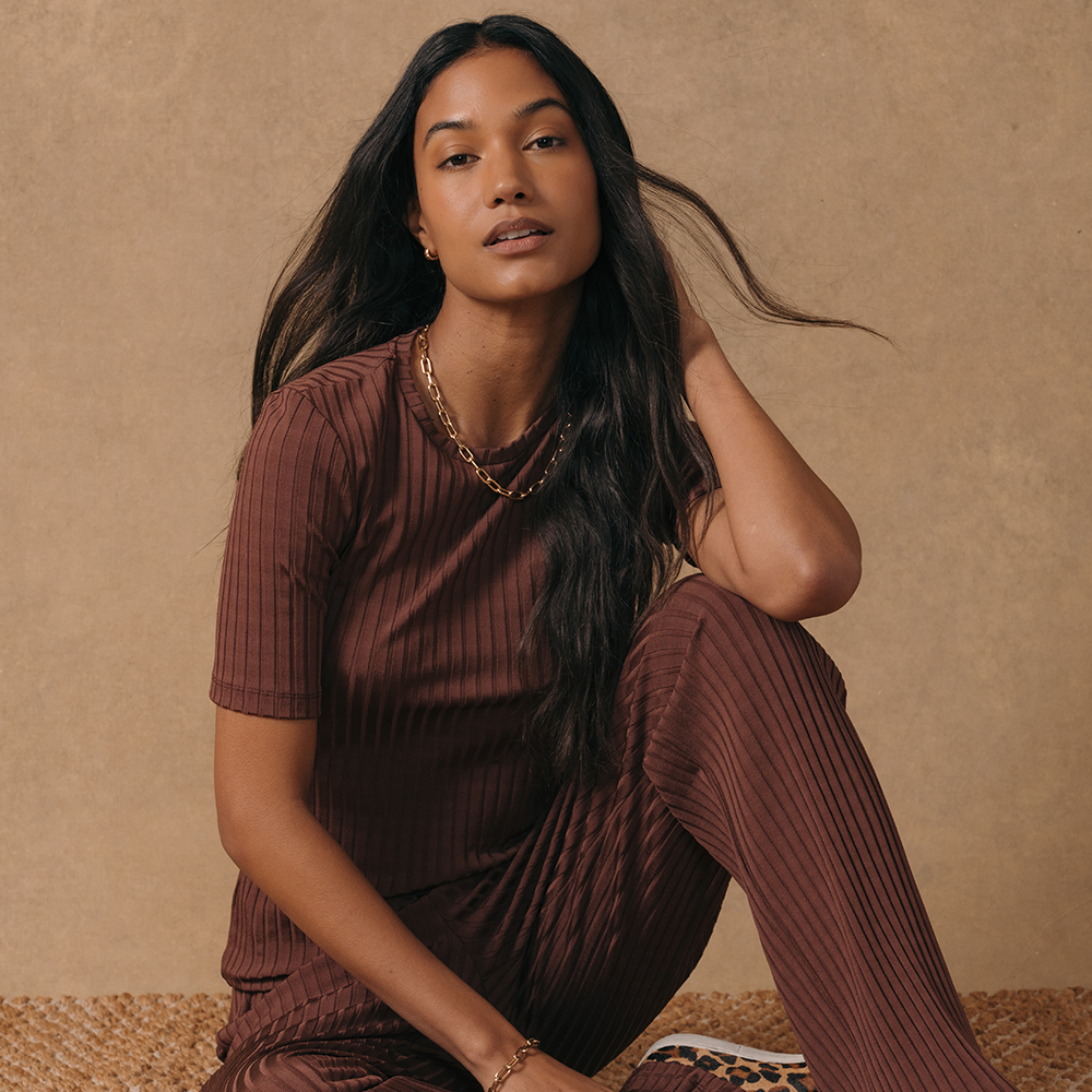A model wearing a knitted ribbed loungewear set in burgundy.