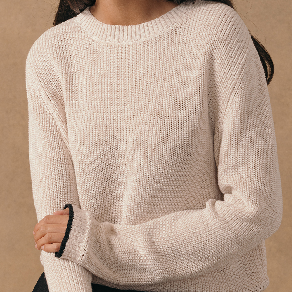The Saint and Sofia Remy crop jumper in beige with contrasting black trims at the cuffs.