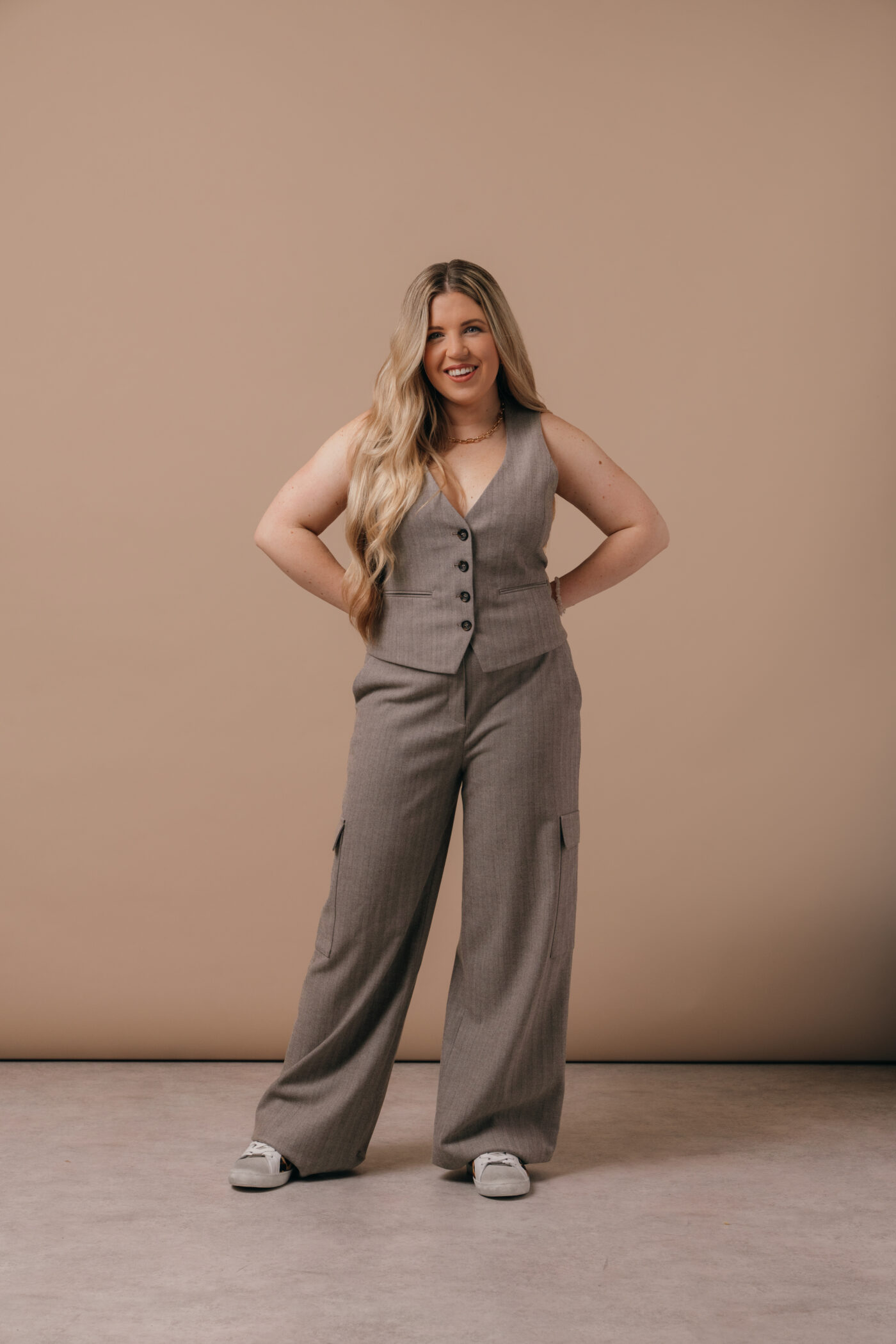 A model wearing the Saint and Sofia Astrid waistcoat in grey with cargo trousers.