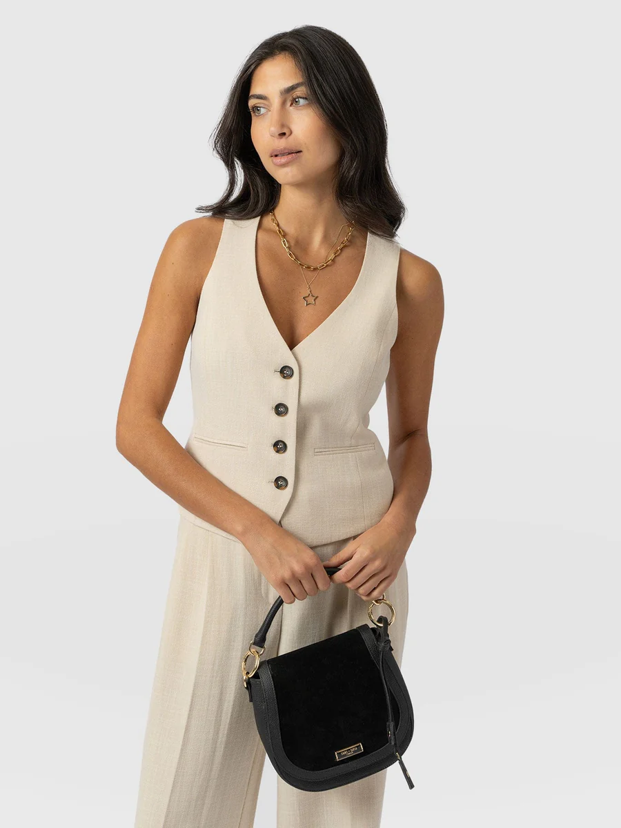 The Saint and Sofia Astrid Waistcoat in cream. A linen-effect design with horn buttons down the front, a V-neckline, and a waist adjuster at the back.