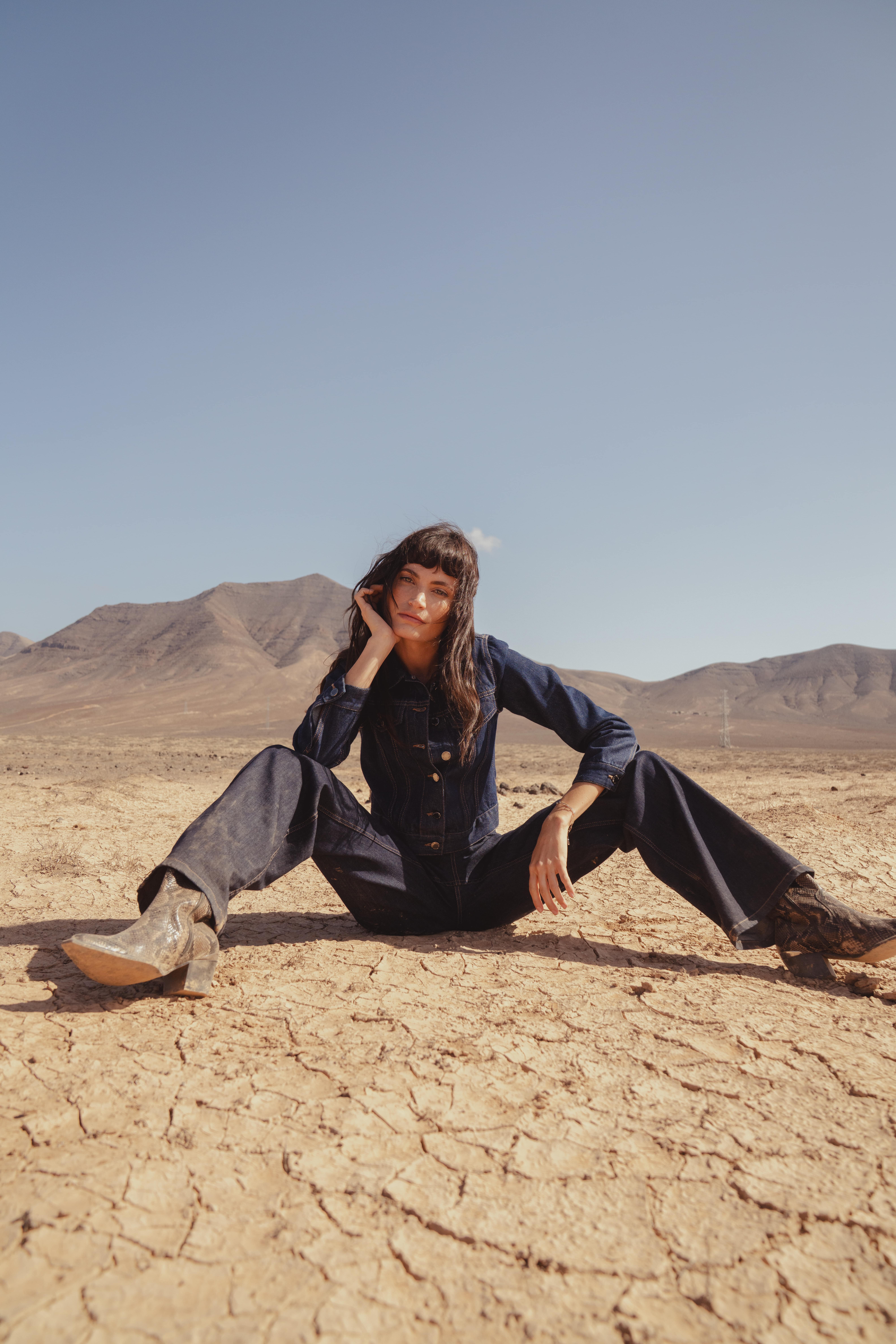 A model sat on the ground wearing the Saint and Sofia Bowie Denim Jacket with the matching Bowie Stretch Flare Jeans for a double denim look 