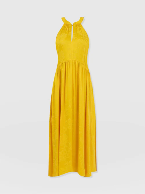 The Zoey Halterneck Dress by Saint and Sofia. A yellow sleeveless design with a slim cut out detail at the chest and all-over floral jacquard texture.