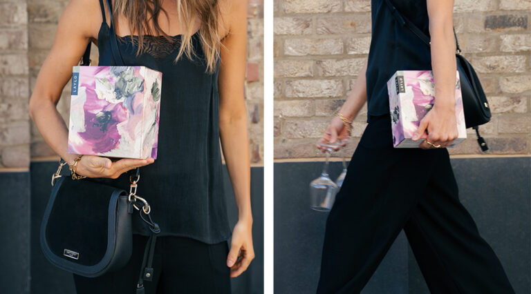 Two images of a model holding a box of Laylo wine. On the left, she wears a Saint and Sofia cami top and the Saint and Sofia saddle bag with the box under her arm. On the right, she walks out of frame holding two glasses of wine.