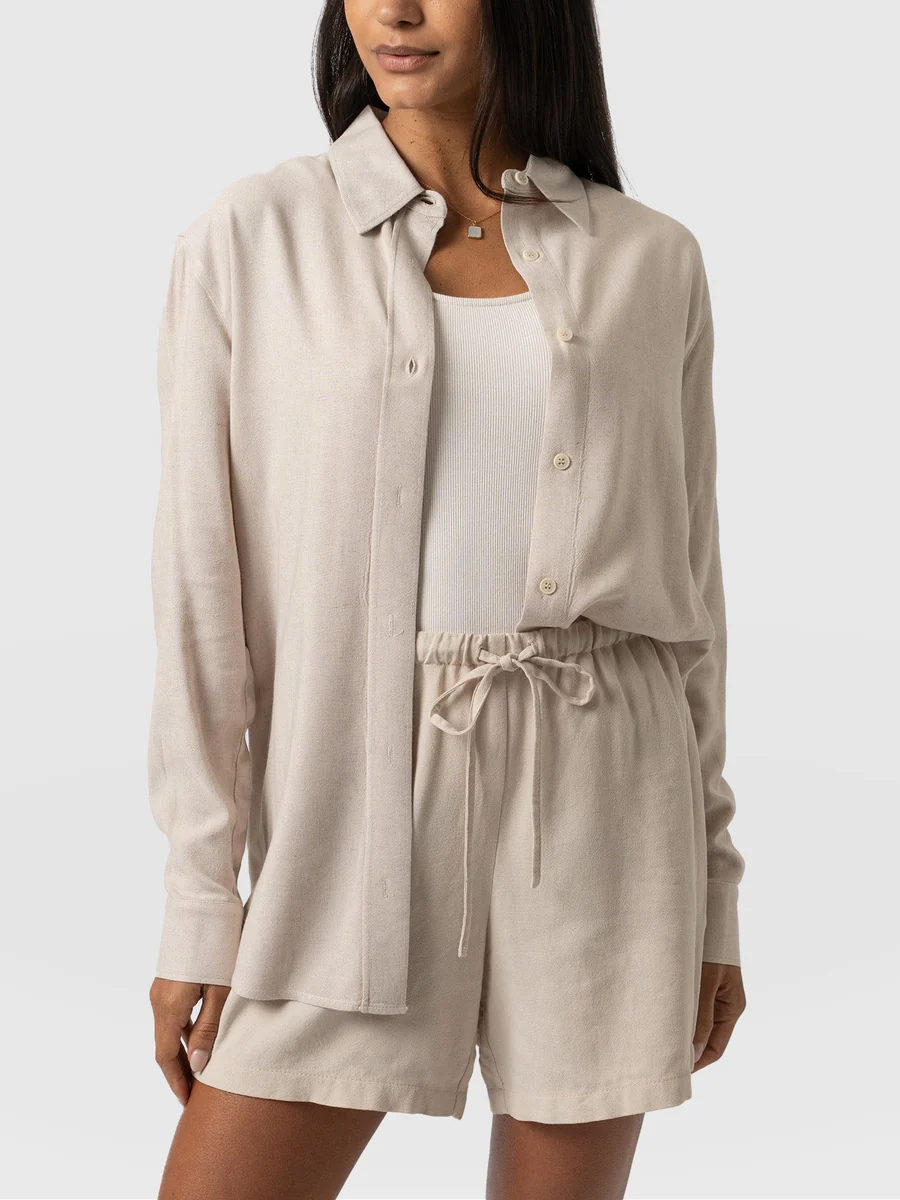 A model wearing the Saint and Sofia boyfriend shirt. A relaxed linen design in an oatmeal hue. The perfect summer essential.