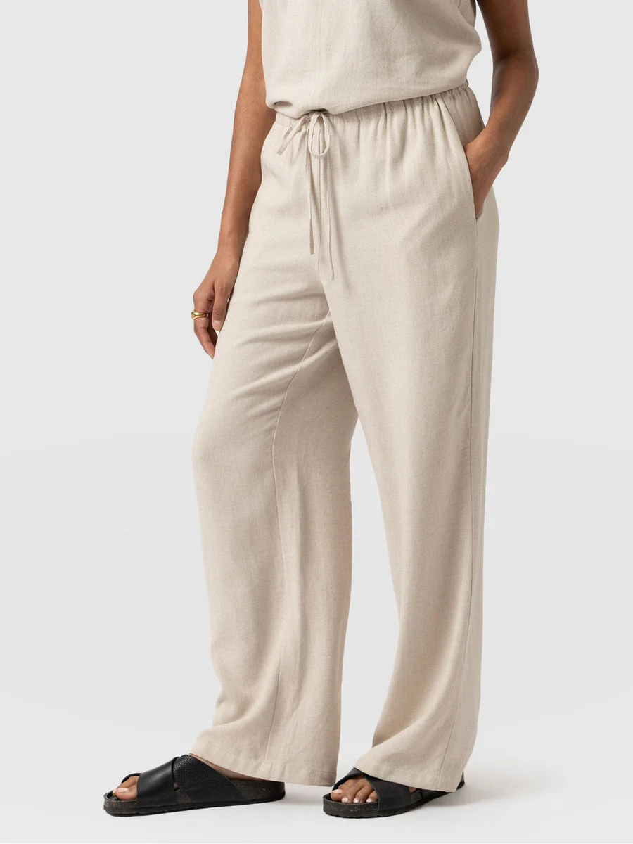 A model wearing the Saint and Sofia Corinne linen trousers. A wide leg design with a self tying waistband.