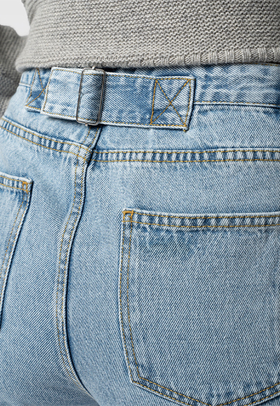 The back of the Saint + Sofia adjustable jeans where a tab has been sewn to the back to allow you to cinch the waist.
