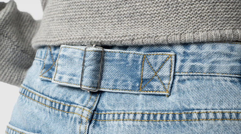 The adjustable buckle at the back of the Saint + Sofia Adjustable Jeans in blue denim