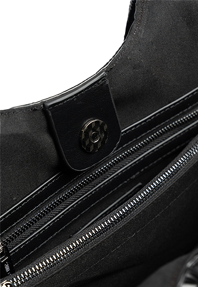A close up of the inside of the Saint + Sofia raffia tote where there are zipped pockets to keep your belongings safe