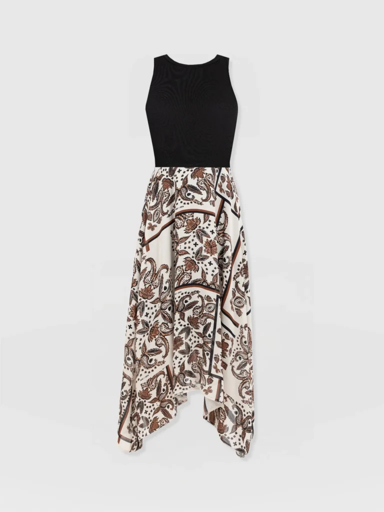 The Saint + Sofia Lila Hanky Hem dress. A contrast design with a black sleeveless jersey bodice and a beige paisley pattern skirt with an asymmetric hem.