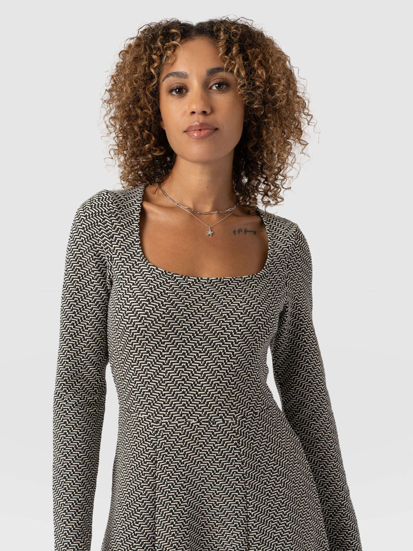 A close up of a model wearing the Dacey dress by Saint + Sofia. A square neck, long sleeve midi dress with an empire neckline that's perfect for apple body shapes.