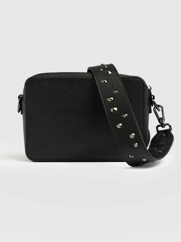 A small square leather camera bag with a gunmetal studded strap from Saint and Sofia