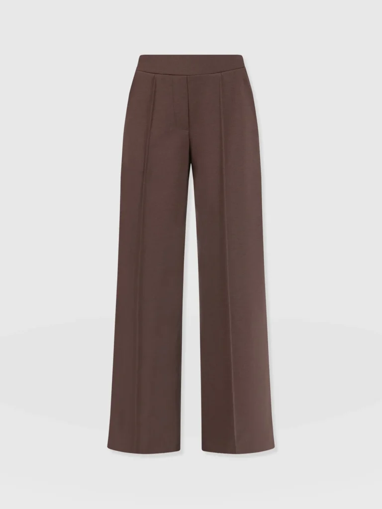 A pair of wide leg trousers with an elasticated waistband and pin tuck detailing down each leg. In brown.