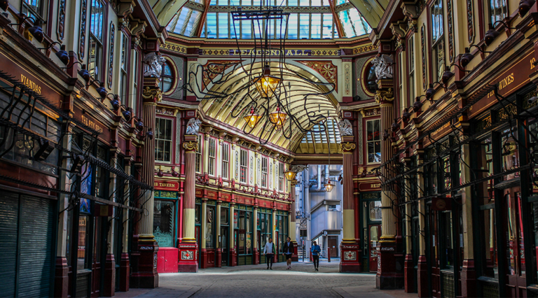A picture of an empty Leadenhall Market in London, England. A grand shopping district with cobbled streets and a glass roof.
