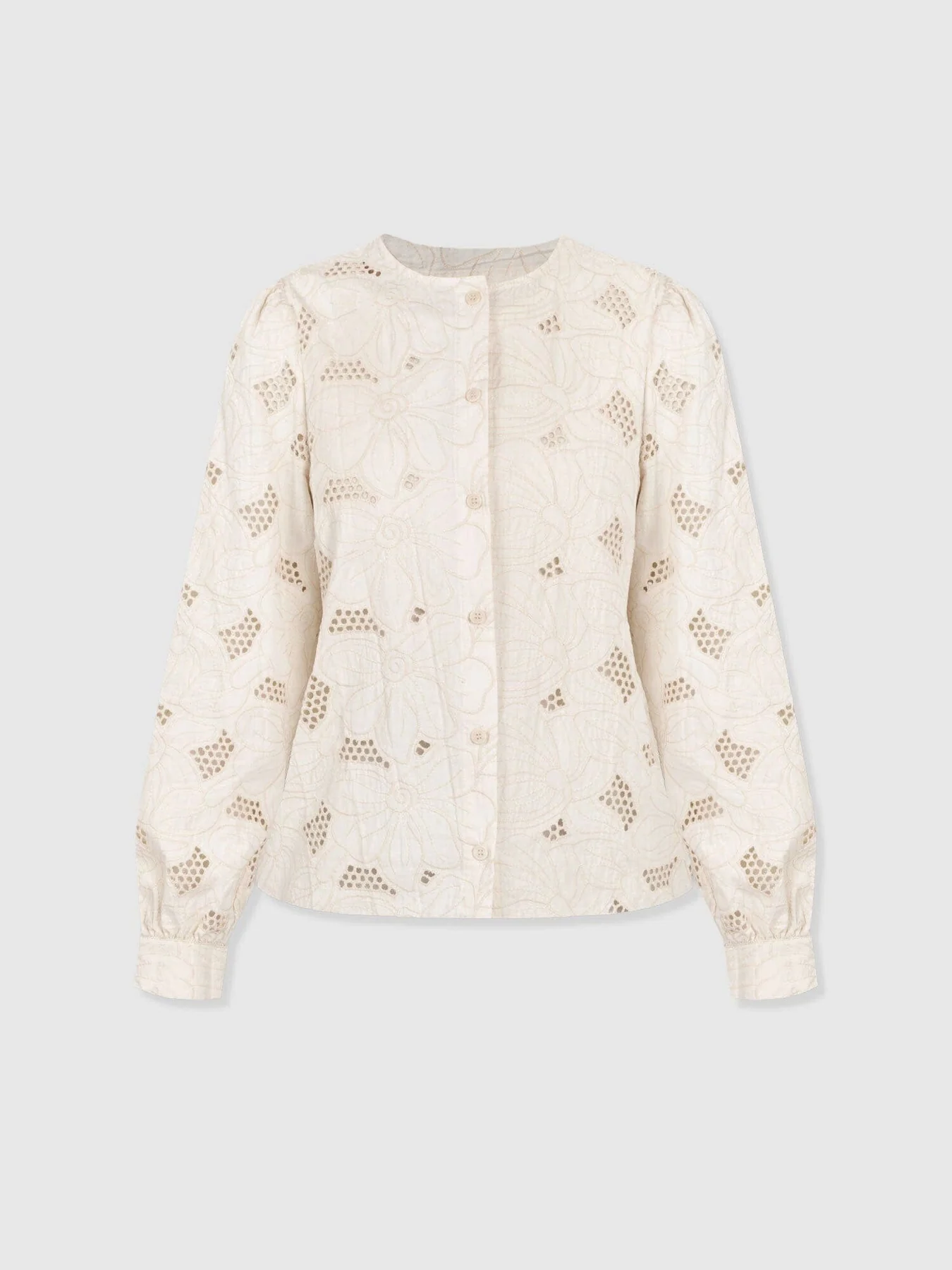 A cut out image of the Tabitha Blouse in Cream Floral by Saint and Sofia. A long-sleeved design with a button-front fastening, crew neckline, and buttoned cuffs. It features floral embroidery and cut out detail for a semi-sheer finish.